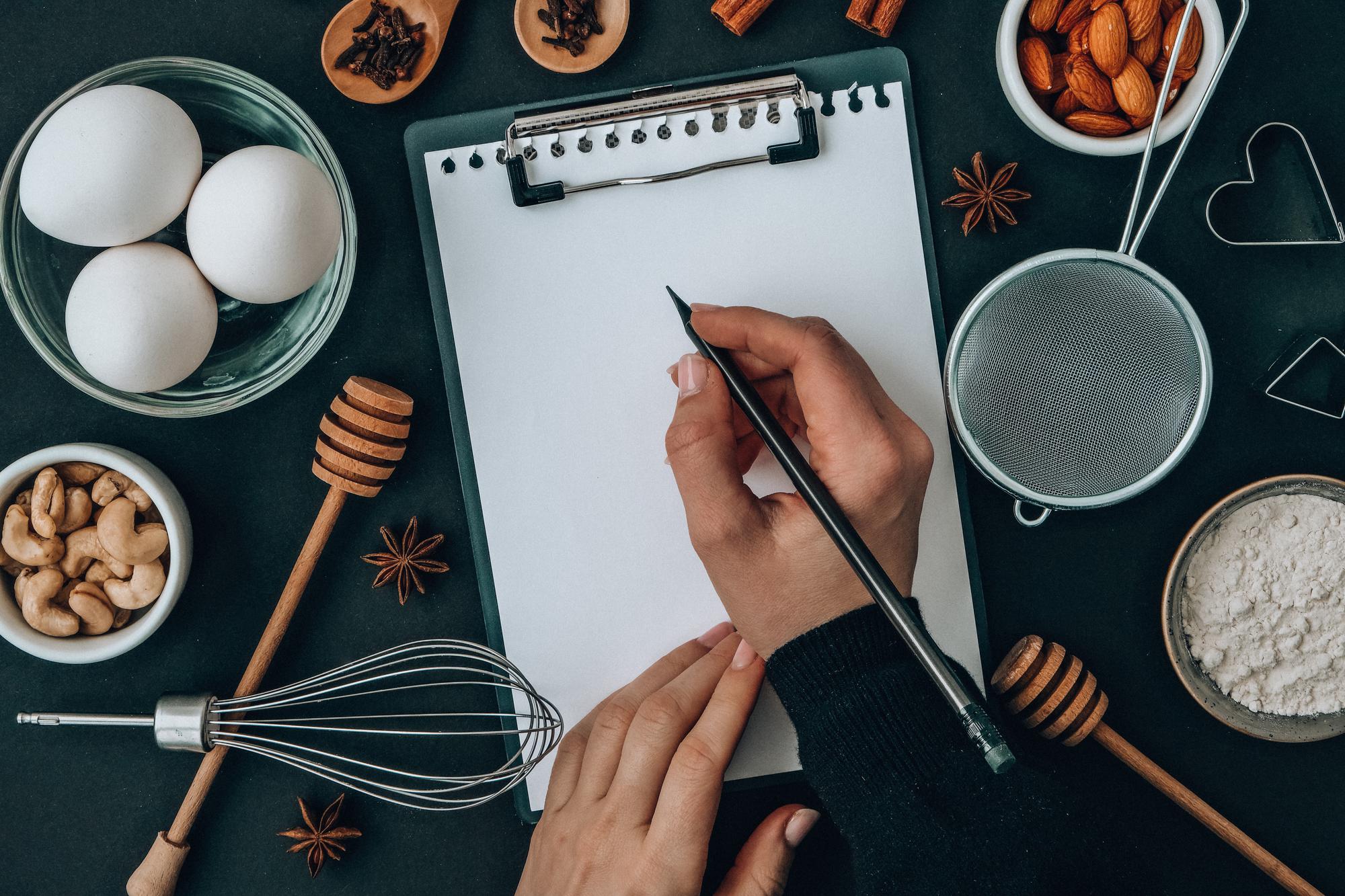 chef writing recipe notes in studio kitchen
